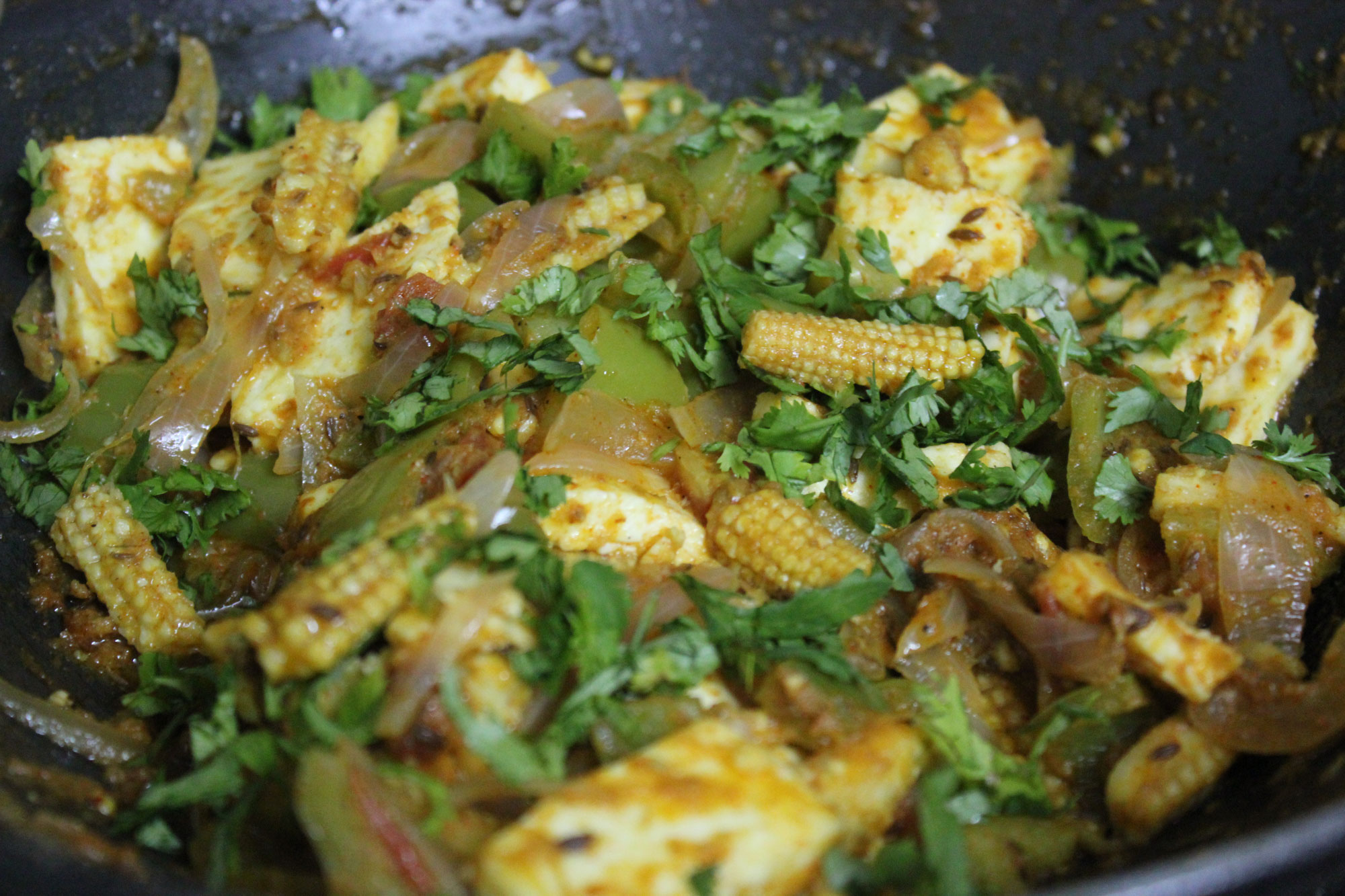 Photograph of an Indian dish with paneer (a type of cheese) and baby corn.
