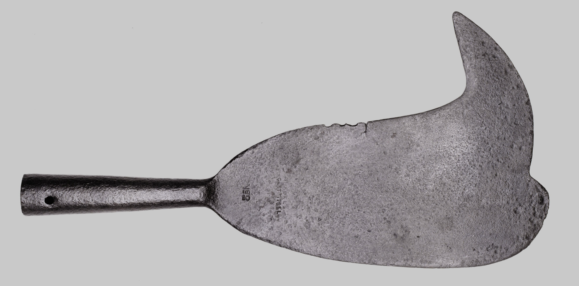 Photograph of a sugarcane knife used by enslaved people to harvest sugarcane in the Danish West Indies in the 1800s. The photo shows a metal knife with a broad, curved blade and a thin metal handle.