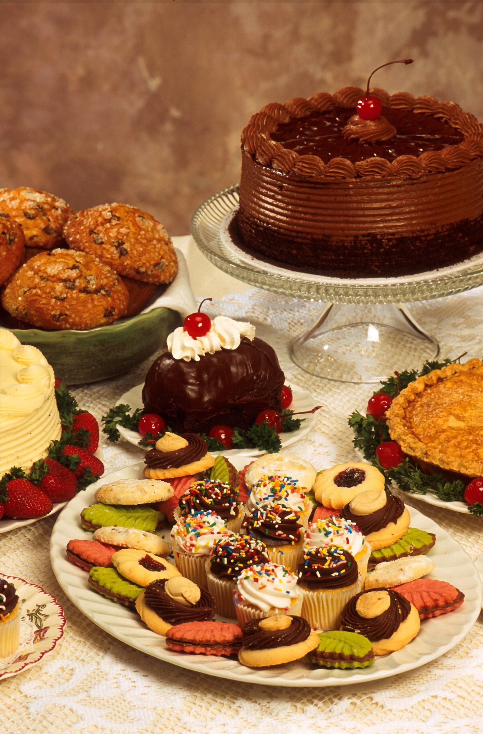 Photograph of a variety of baked goods, including cupcakes, cookies, muffins, a pie, and cake.