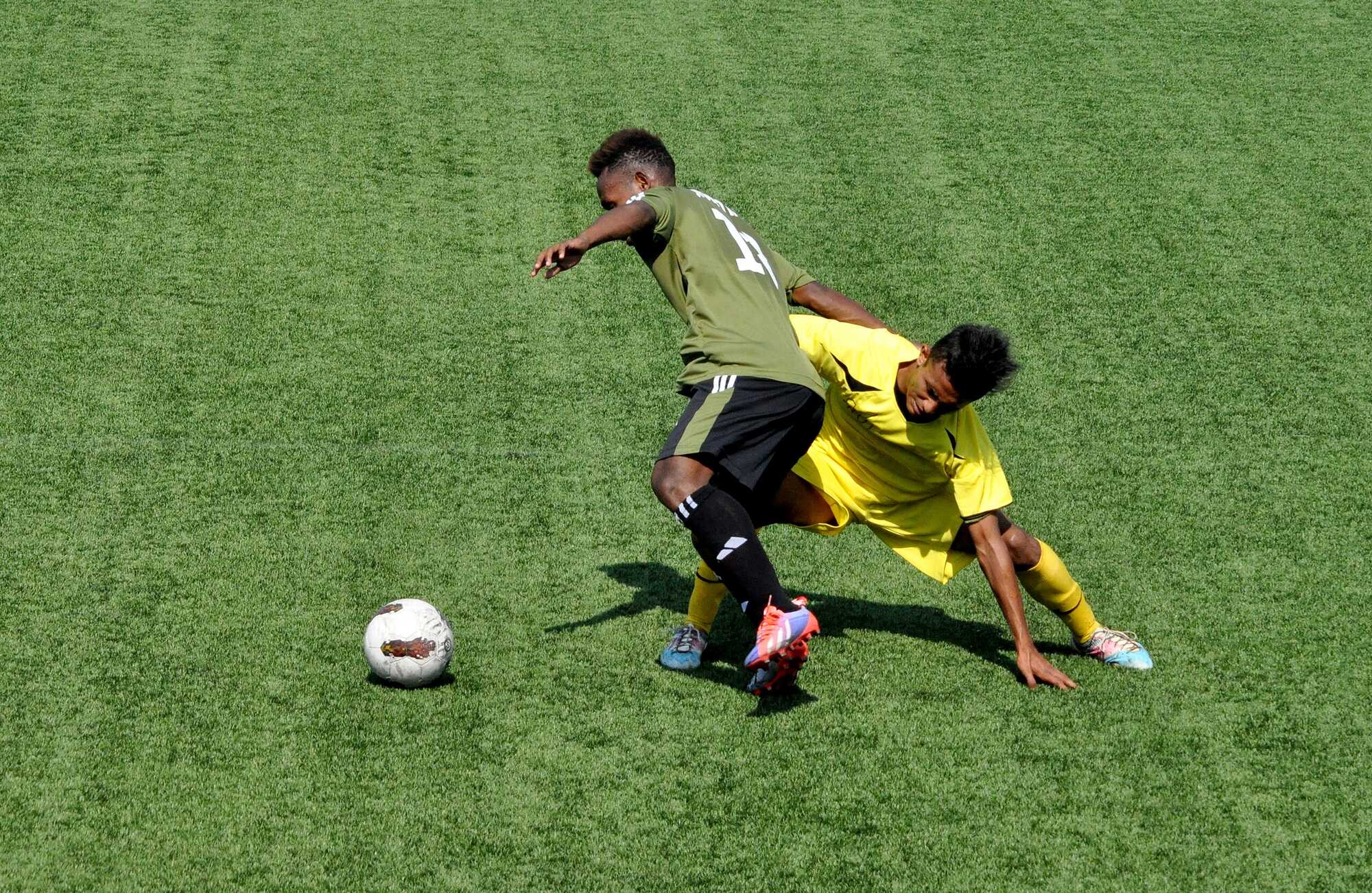 Photograph of two boys playing soccer on synthetic turf.